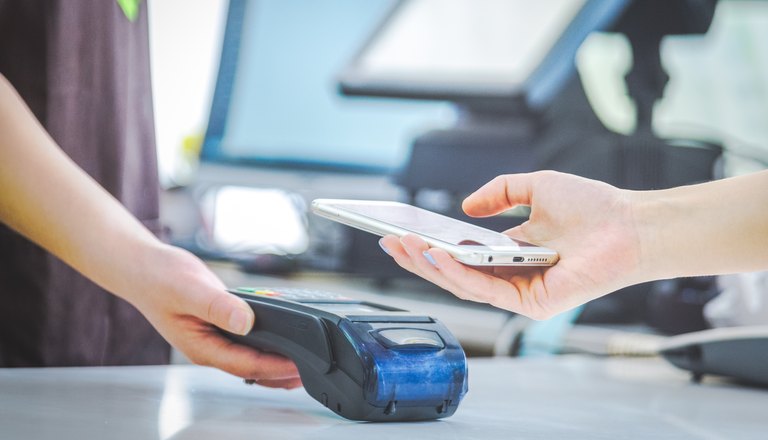 Customer tapping a card on a payment terminal