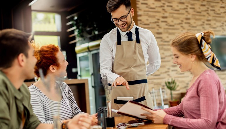 Waiter taking an order from customers at a table